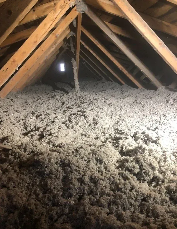 There is a lot of insulation in the attic of a house.