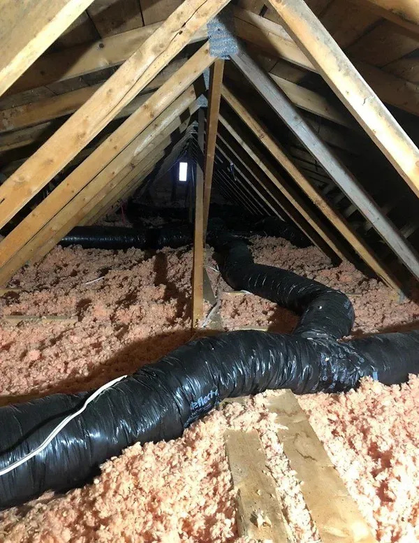 An attic with a lot of insulation and ducts