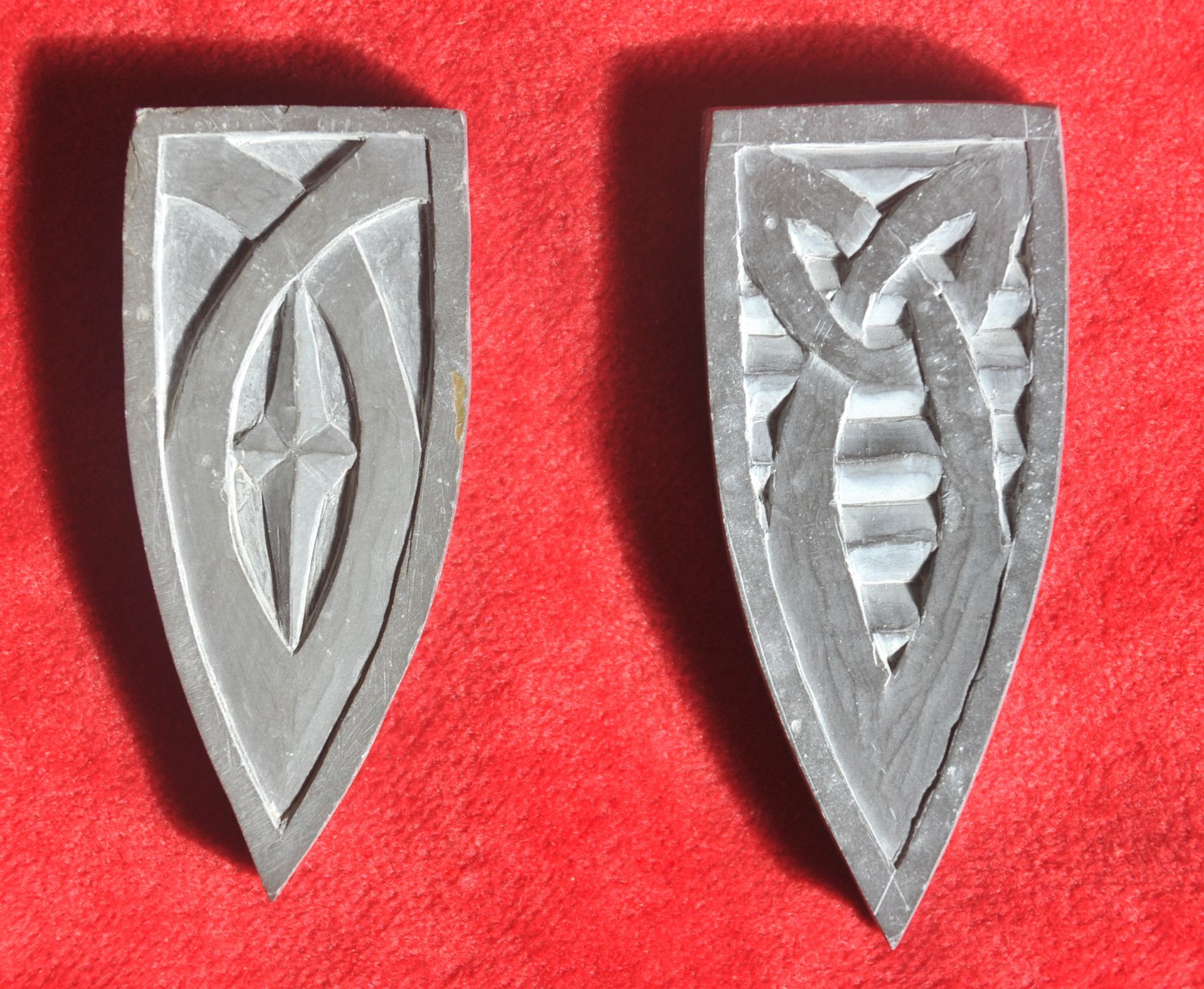 Hand cut and engraved stone pendants in the shape of shields in Devonian Mudstone,