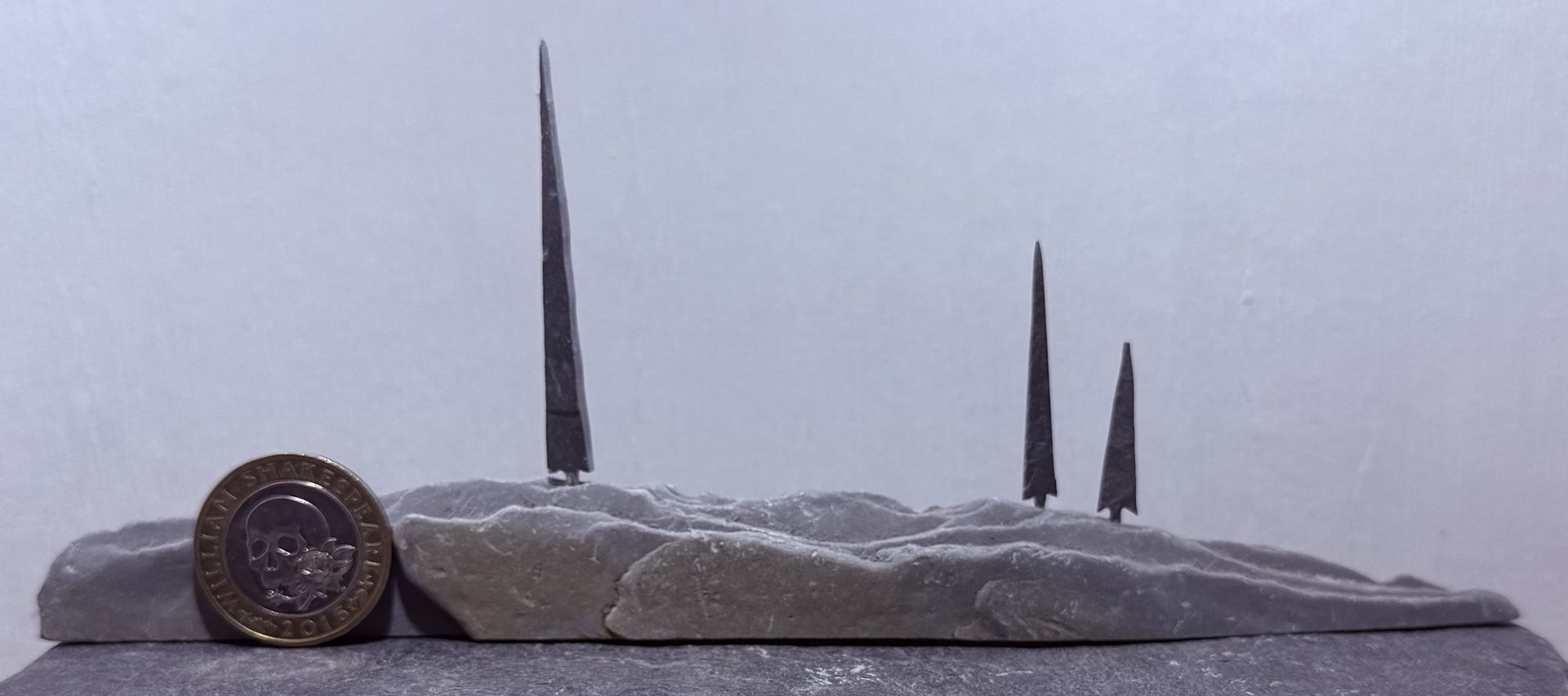 3 Tiny Tall Trees on a Hill with £2 coin for scale 3 Tiny Tall Trees on a Hill