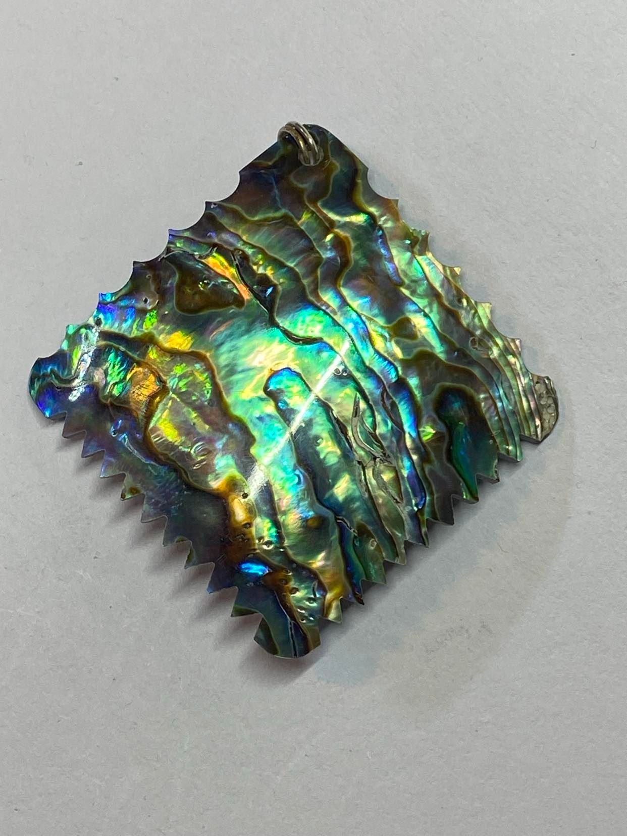 Square Paua Shell with zig zag and curveded carvings Paua Shell pendant with zig zag pattern on the edge.