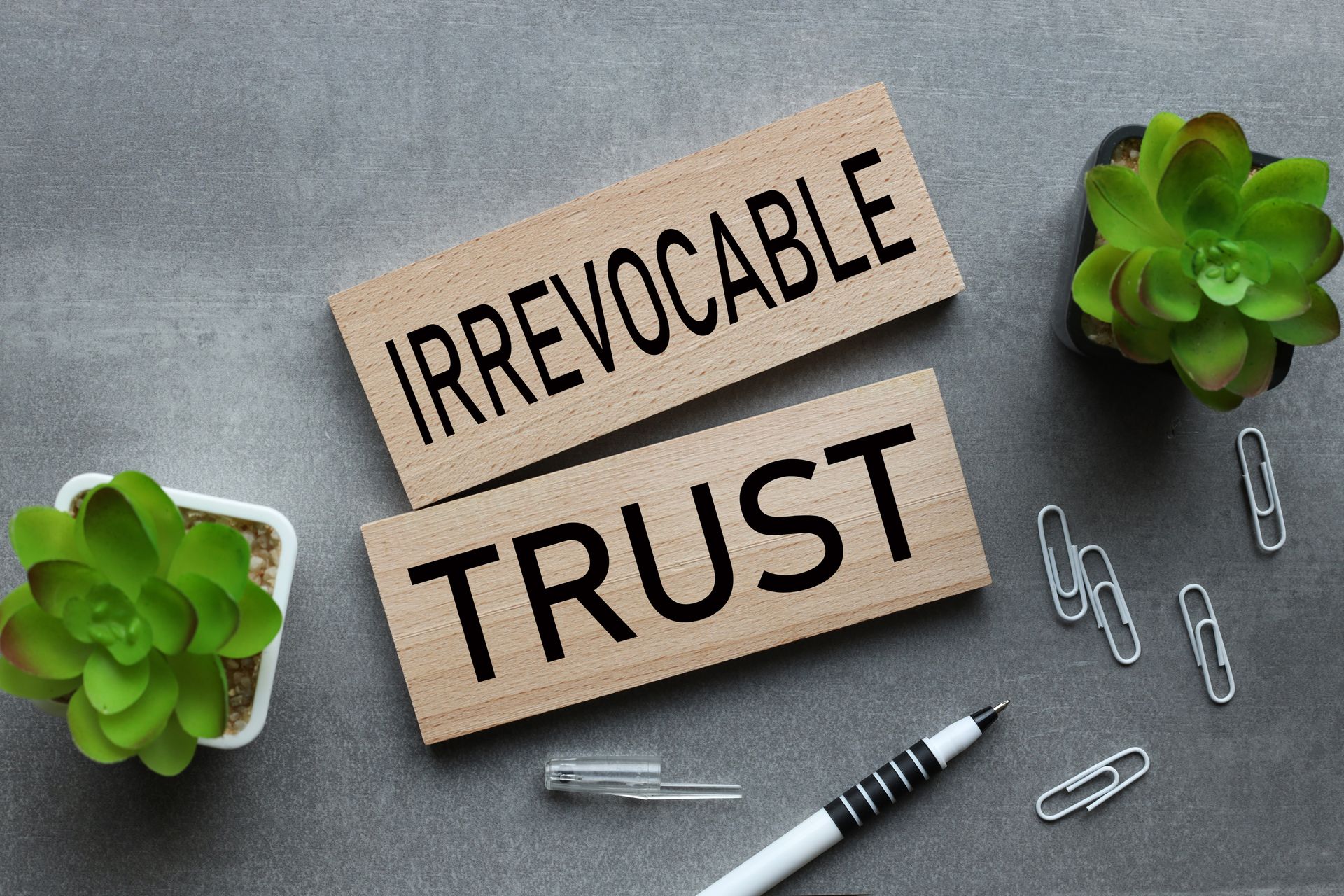 A wooden sign with the words `` irrevocable trust '' written on it.