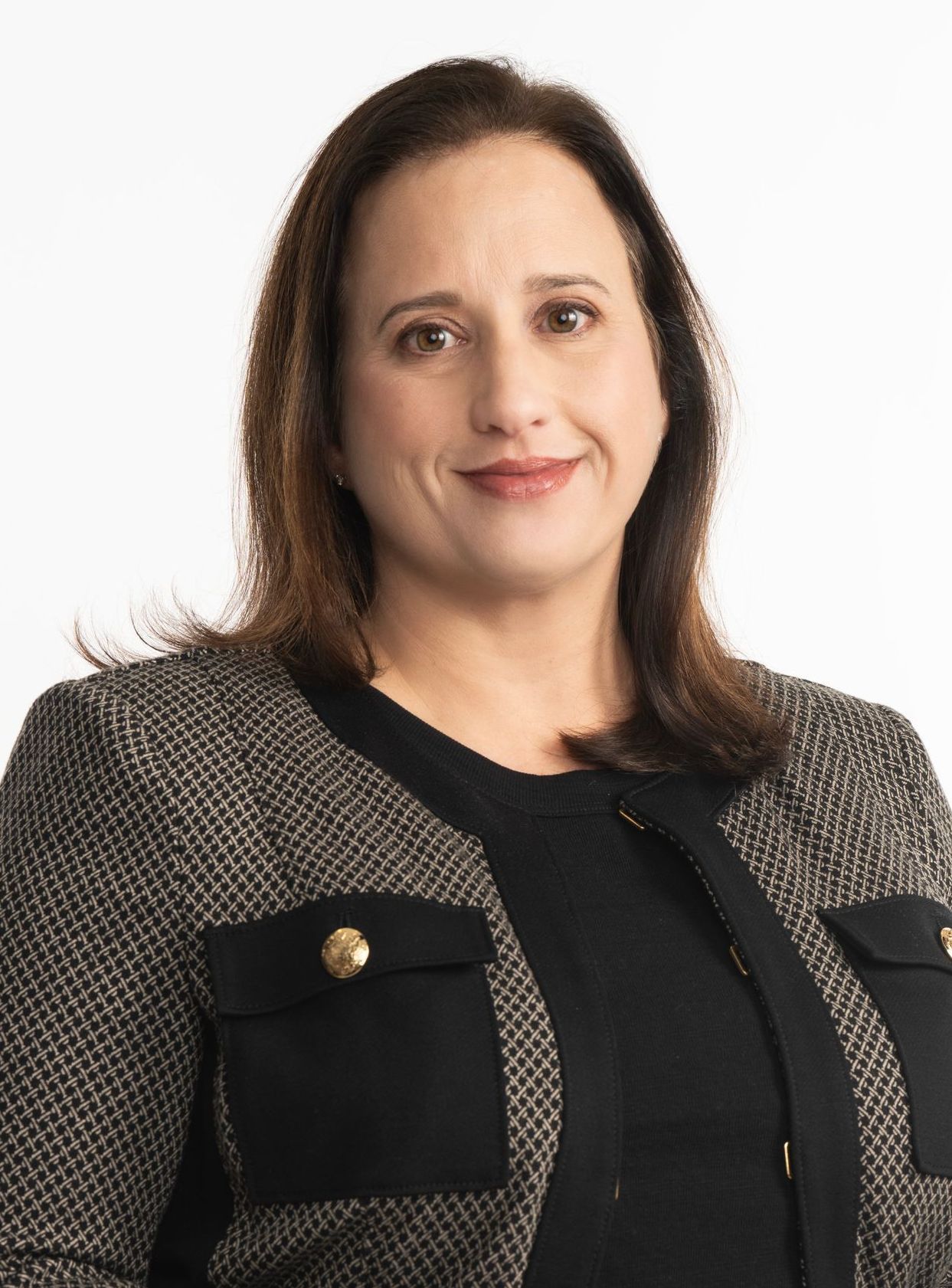 Portrait of a woman in a black and gray textured jacket against a white background