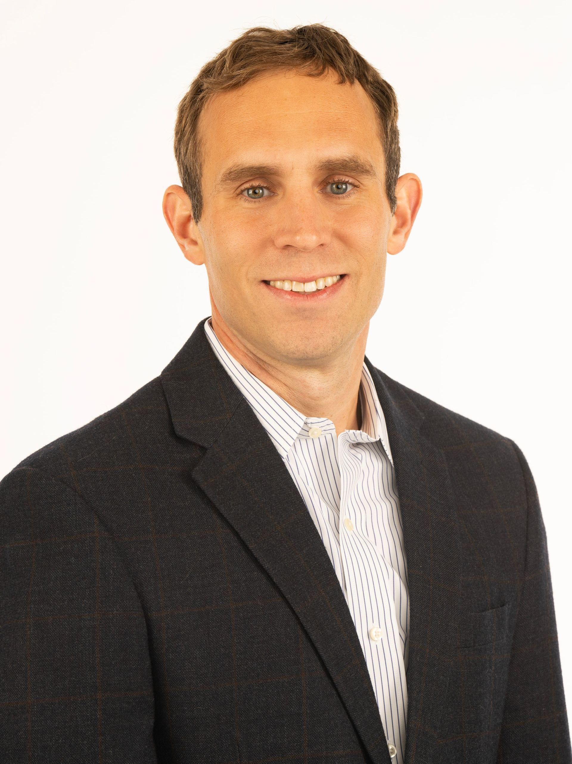 A man in a suit and tie is smiling for the camera.