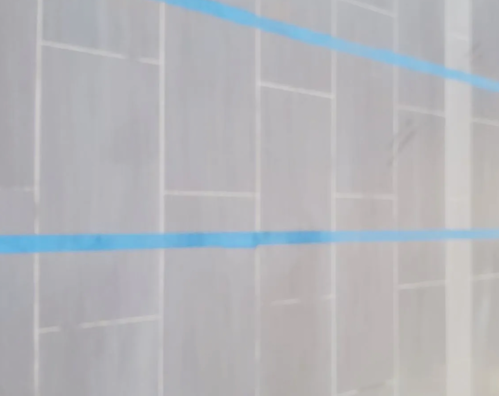 A close up of a wall with blue tape on it.