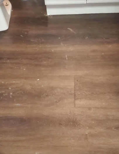 A close up of a wooden floor in a kitchen.
