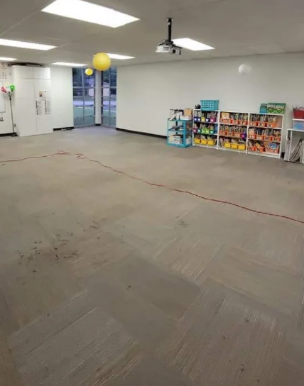 An empty room with shelves and a projector on the ceiling