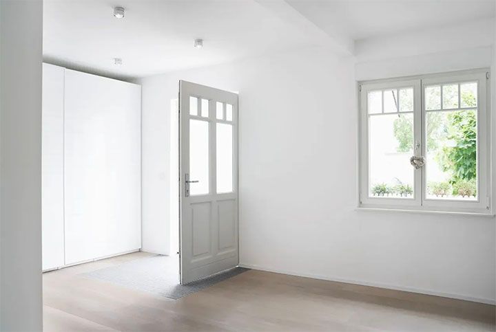 An empty room with a door and a window.
