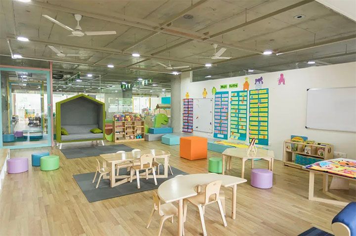 A large room with tables and chairs in a classroom.