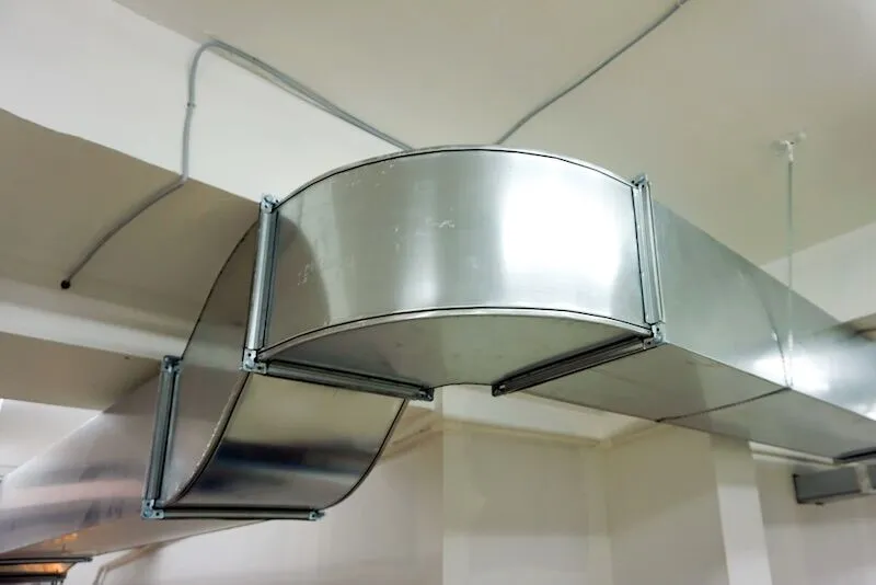 A large metal pipe is hanging from the ceiling of a building.