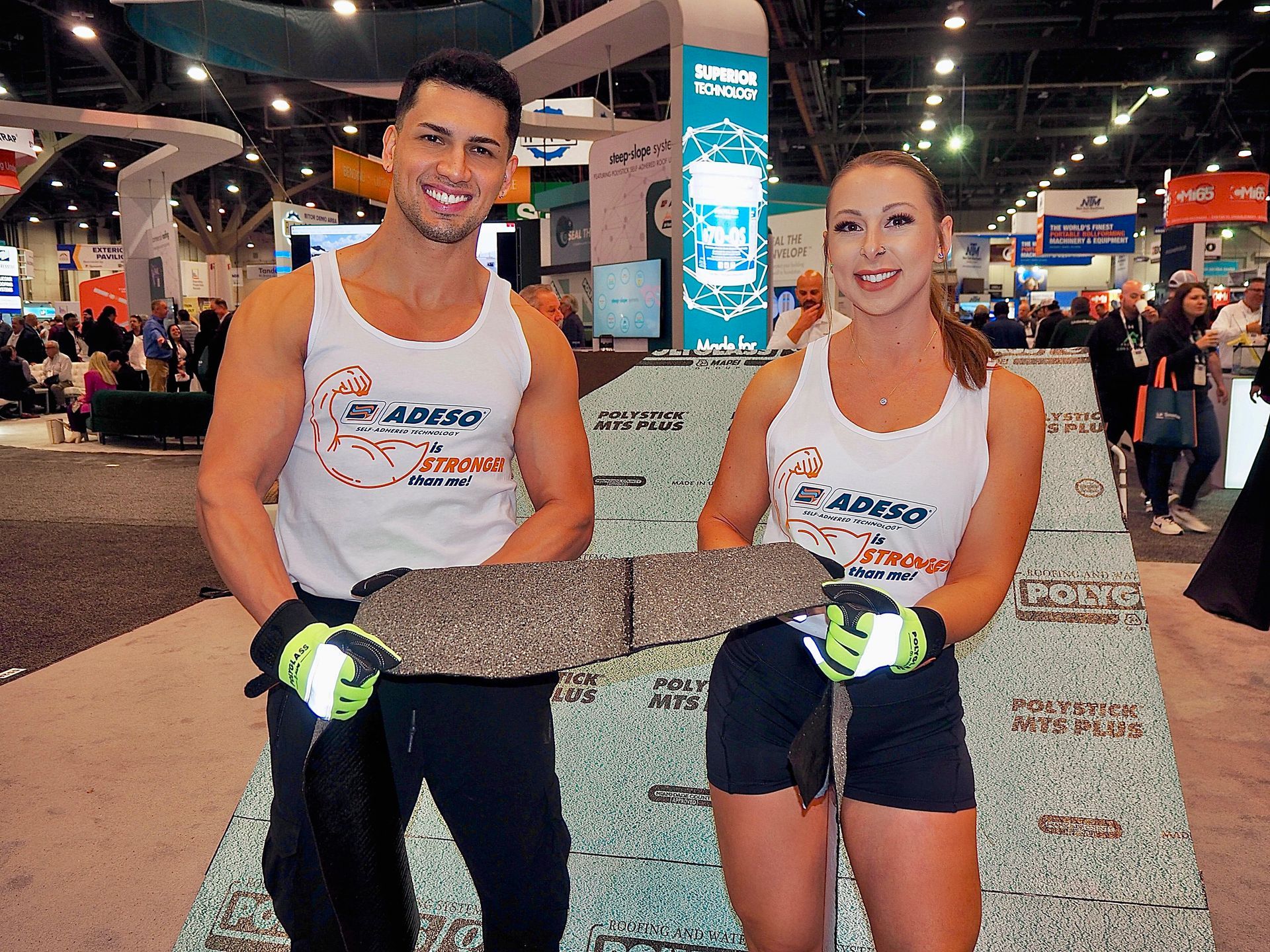 Professional fit models holding product in trade show booth at the roofing expo in Las Vegas.