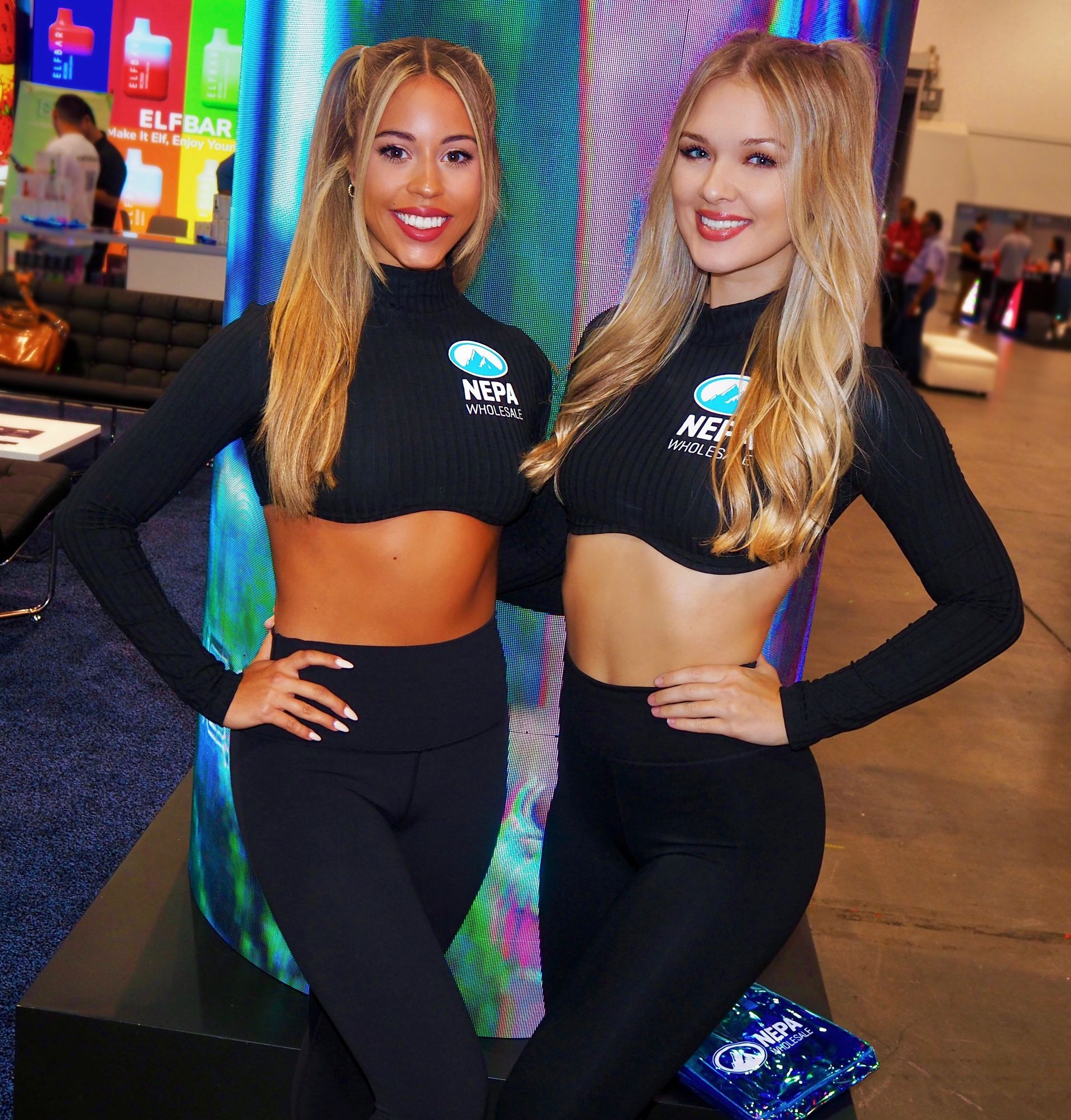 Blonde professional trade show models smile for photos in the Nepa Wholesale booth at ASD Market Week Las Vegas.