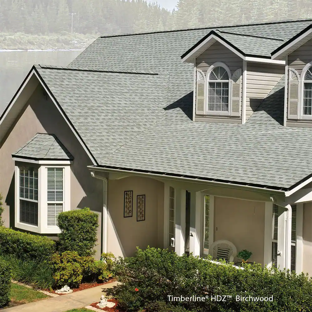 A house with a gray roof and a bay window