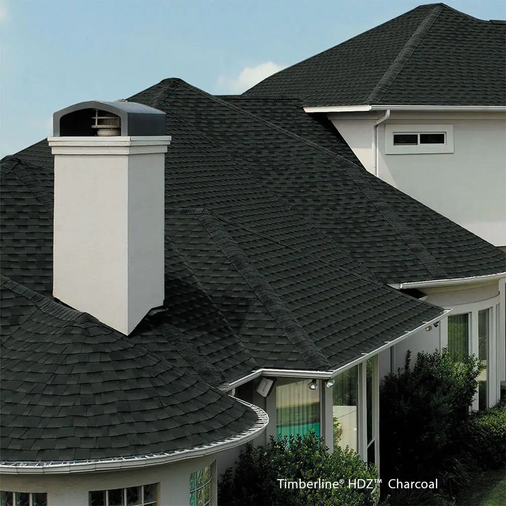 A white house with a black roof and a chimney