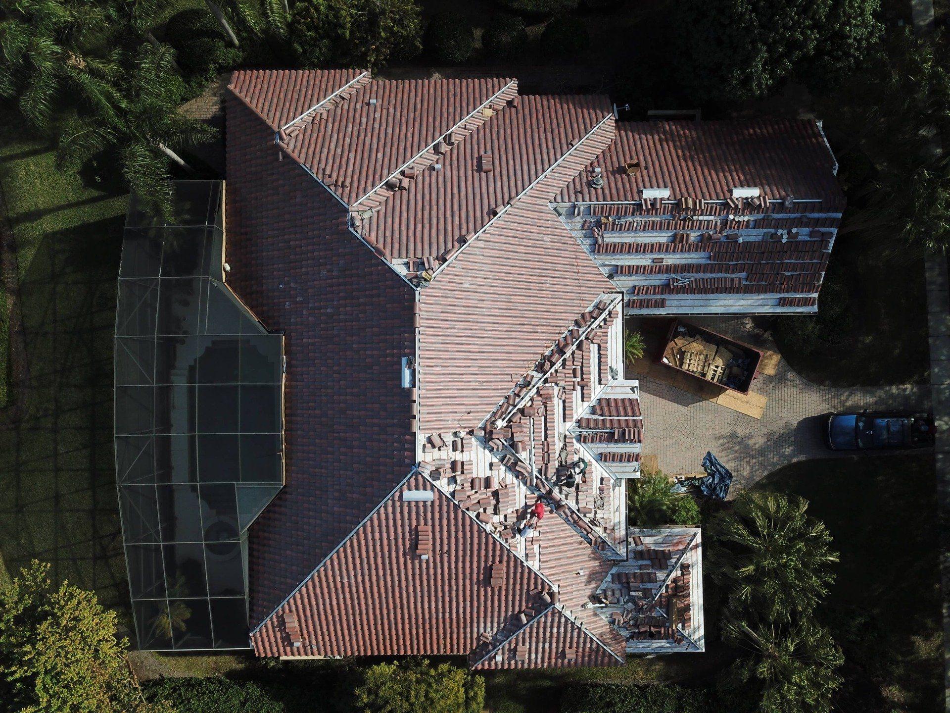 An aerial view of a house with a roof that is being repaired.