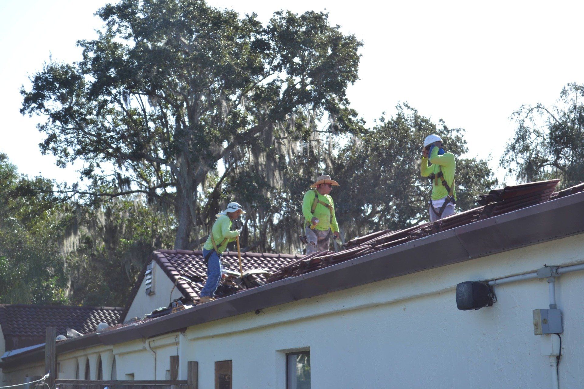 A group of construction workers are working on the roof of a building.