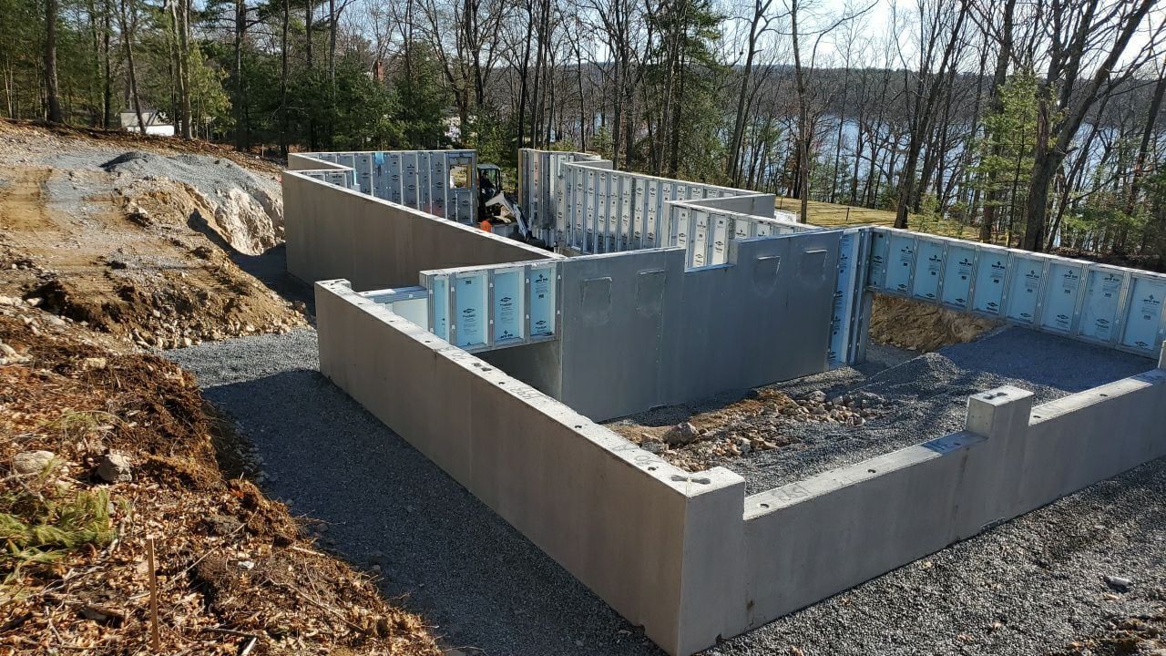 A large concrete wall is being built next to a lake.