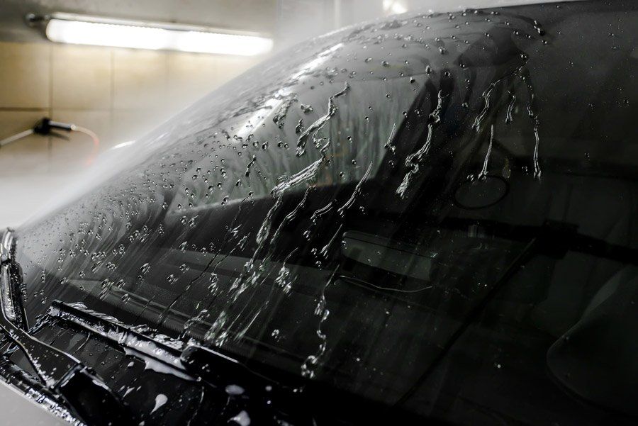a close up of a car windshield with water drops on it .