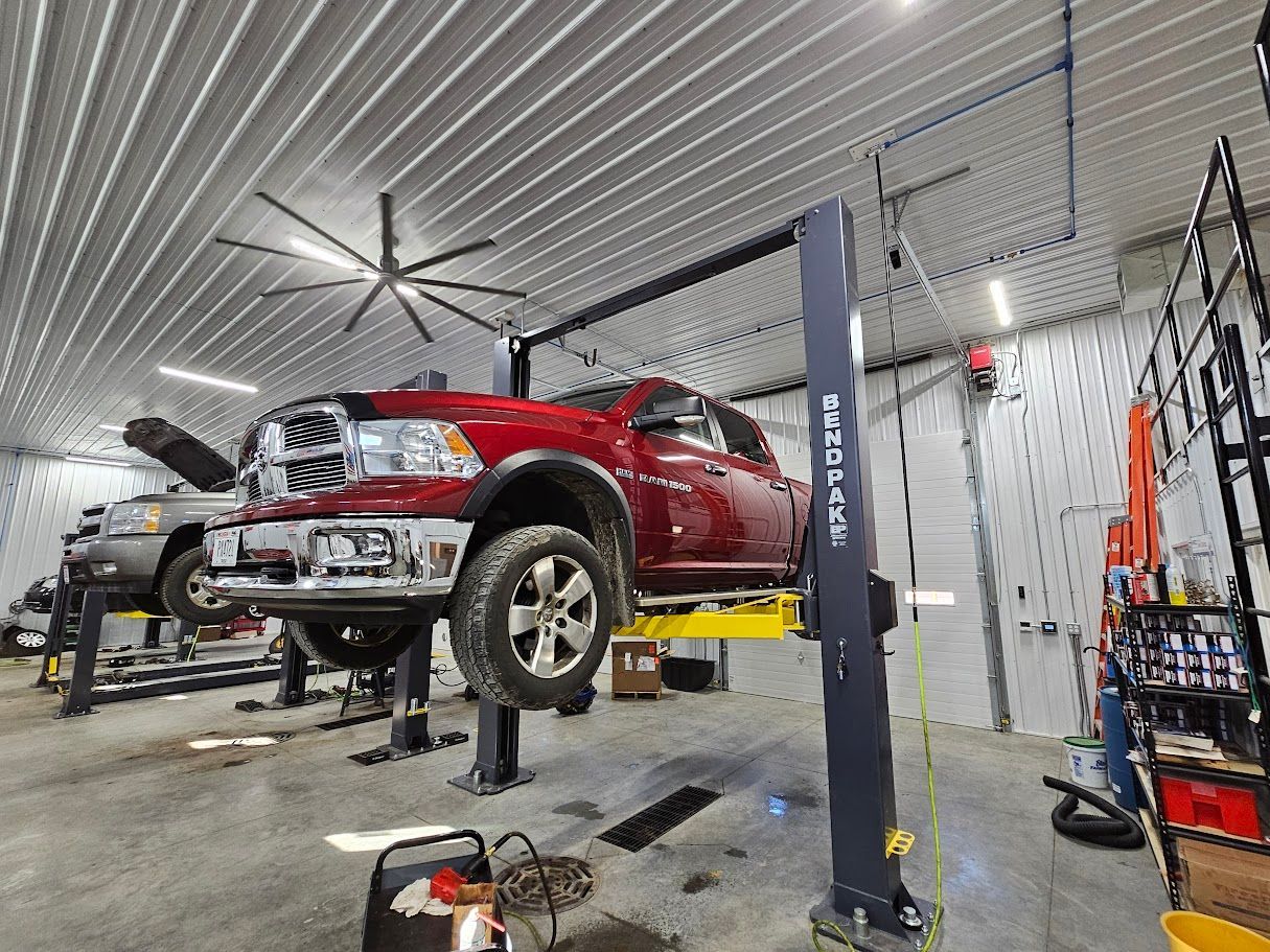 a red truck is sitting on a lift in a garage .