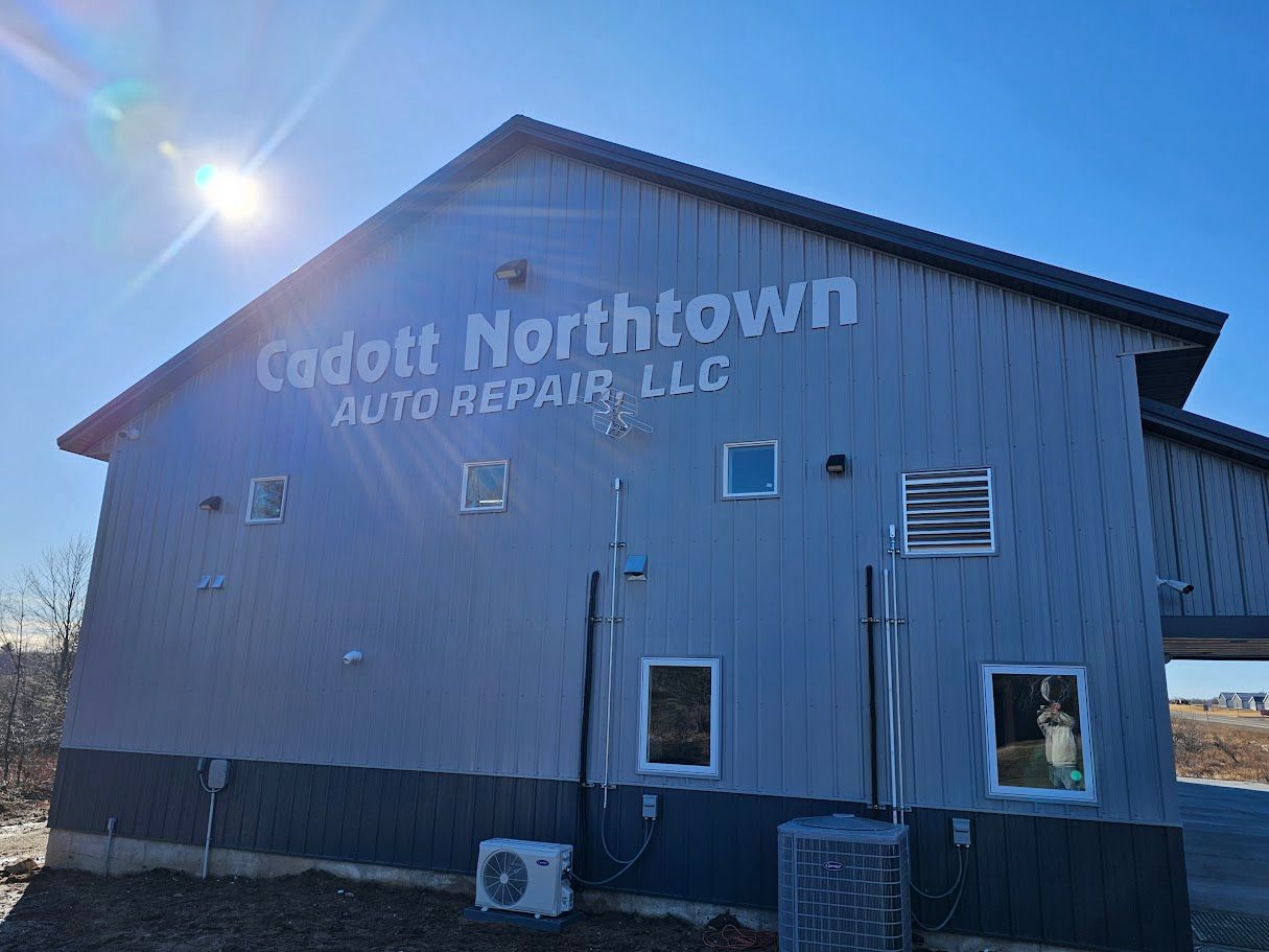 a large gray building with a sign on the side that says `` cadolt northtown auto repair llc '' .