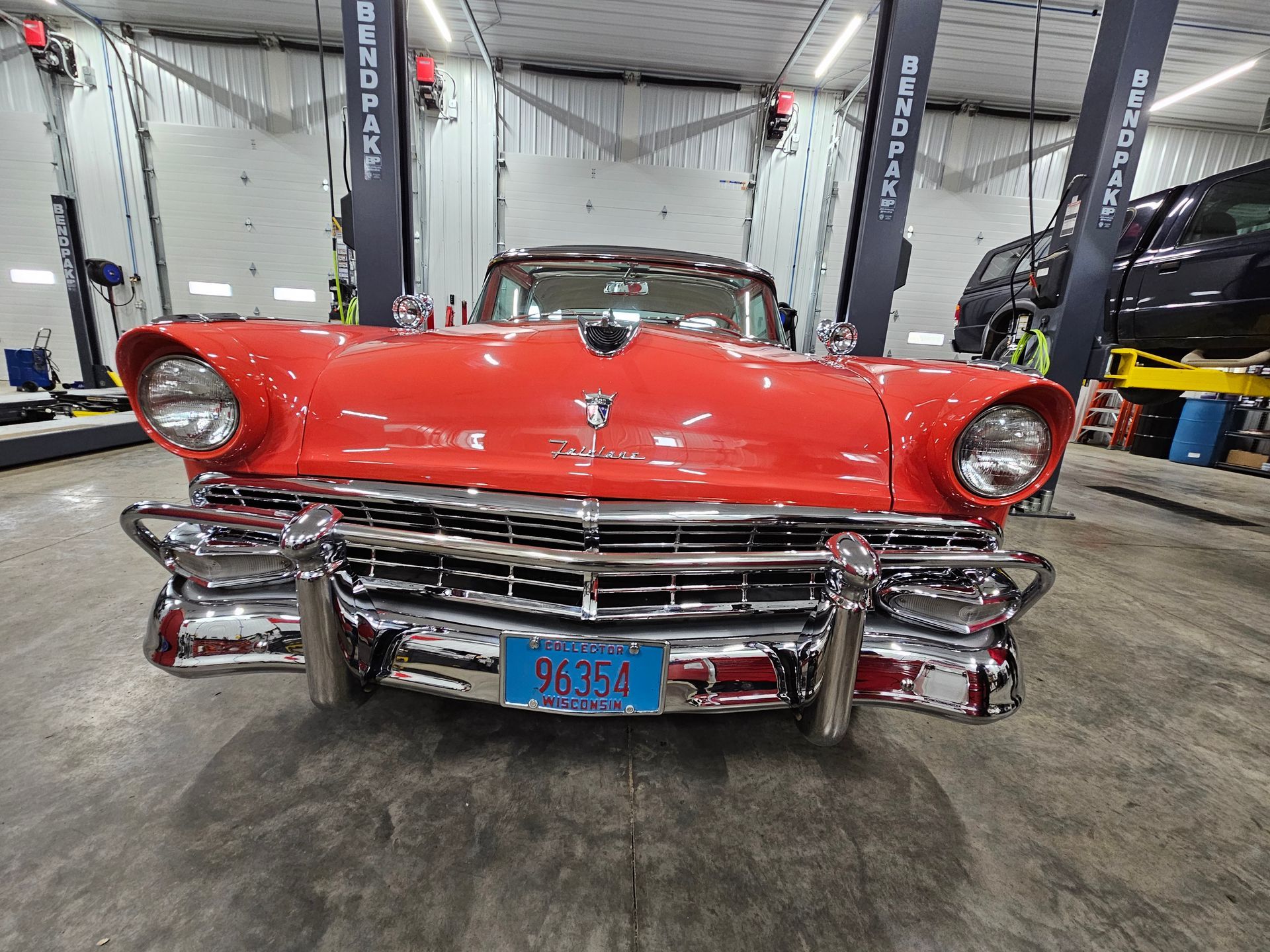 A red cadillac is parked in a garage.