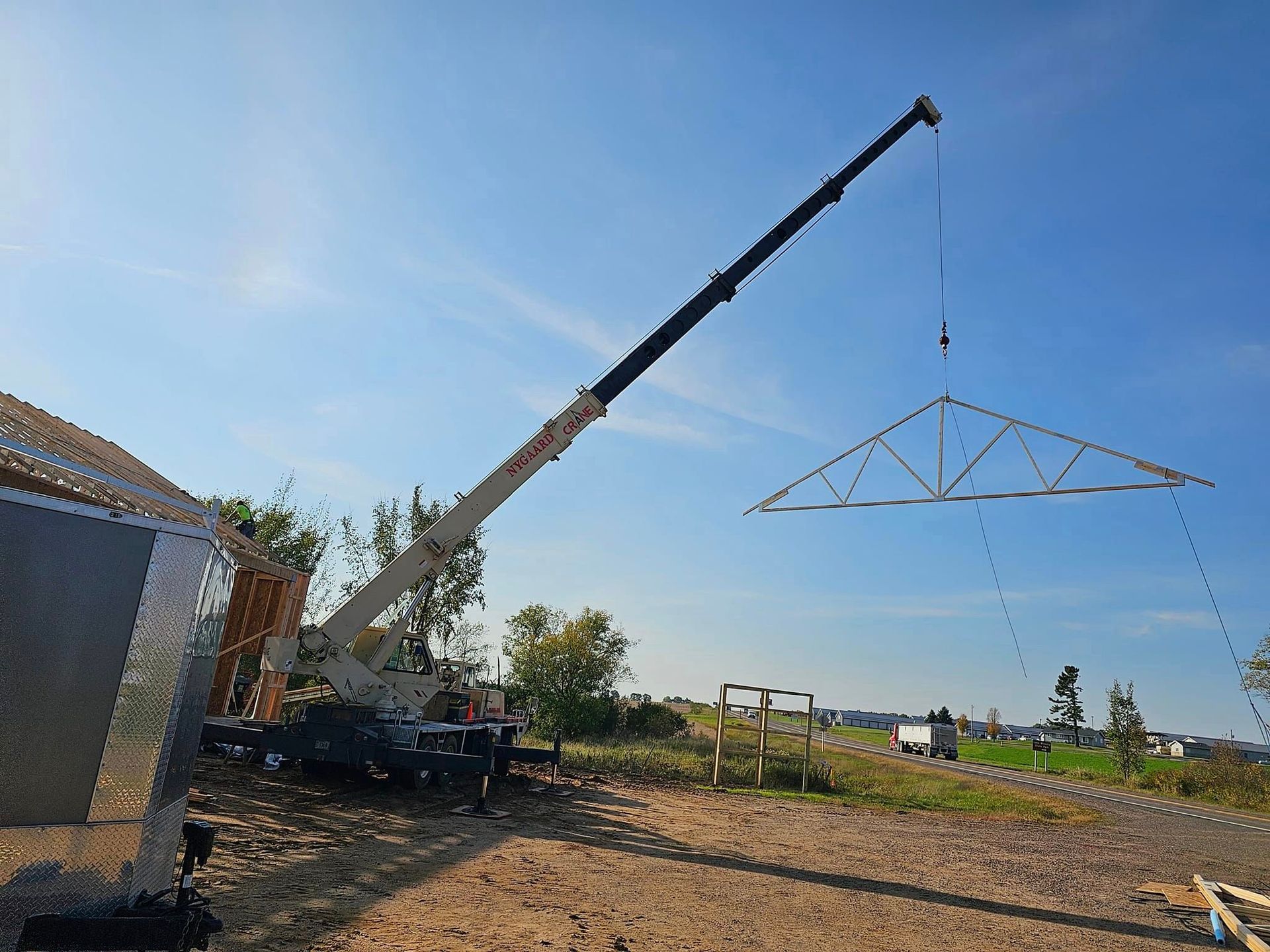 a crane is lifting a metal structure in the air .