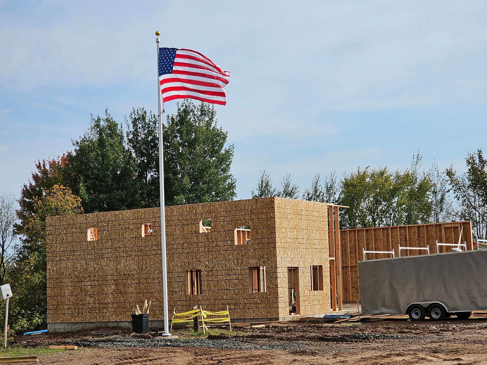 an american flag is flying in front of a building under construction