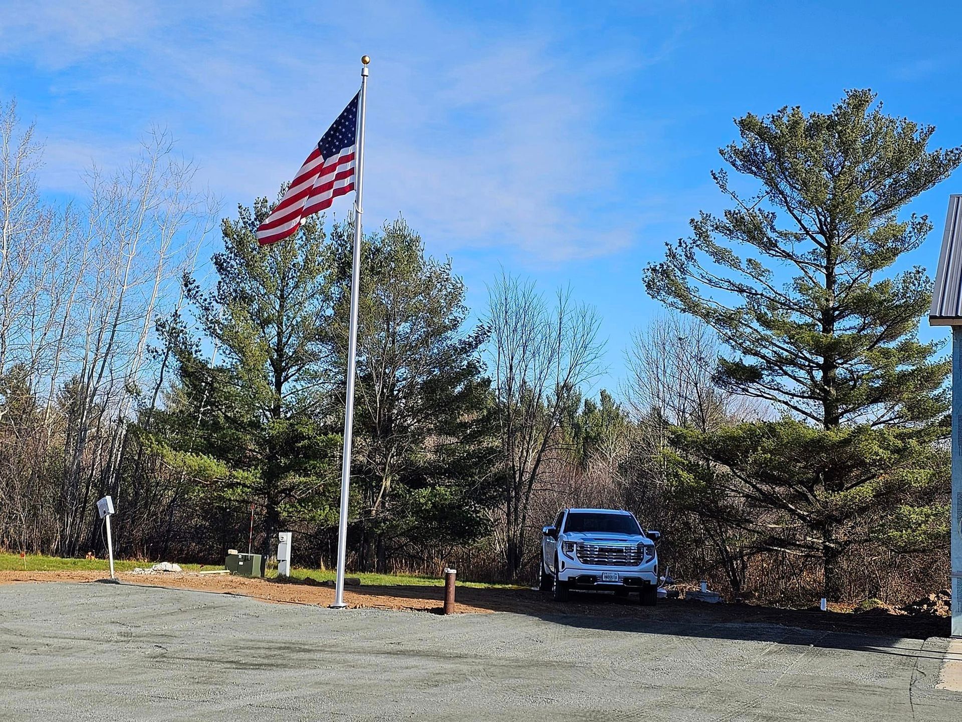 a white truck is parked in front of an american flag