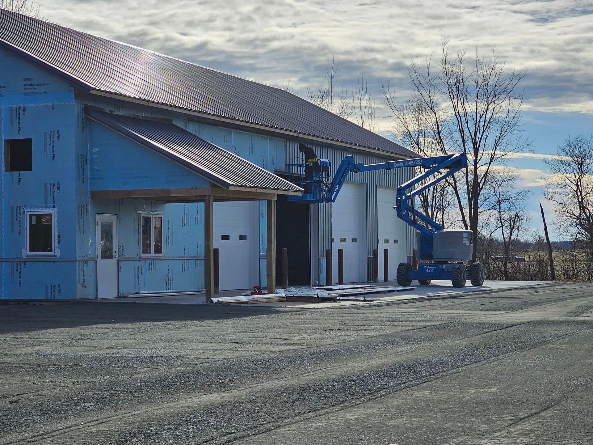 a large blue building with a lift in front of it is being built .