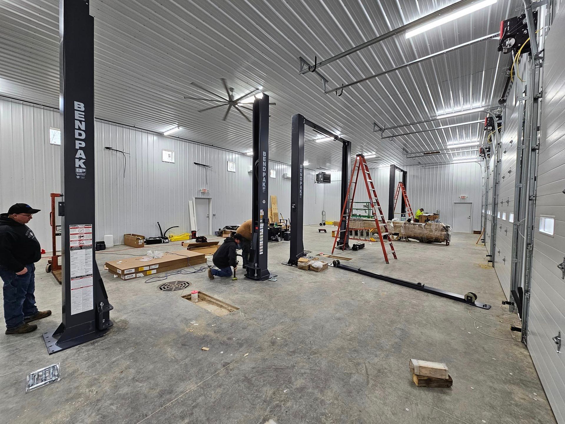 a man is working on a lift in a garage .