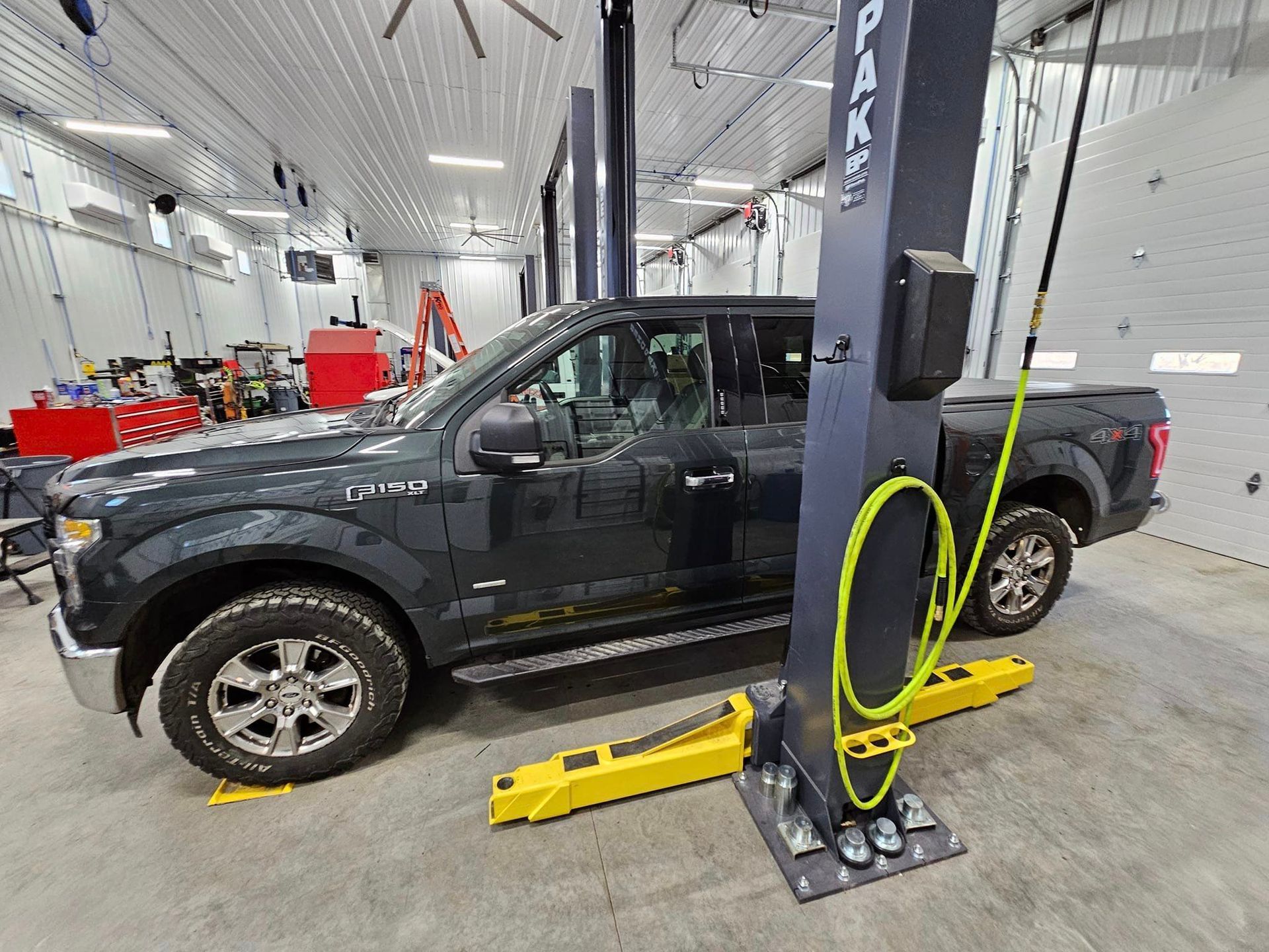 a black truck is parked on a lift in a garage .
