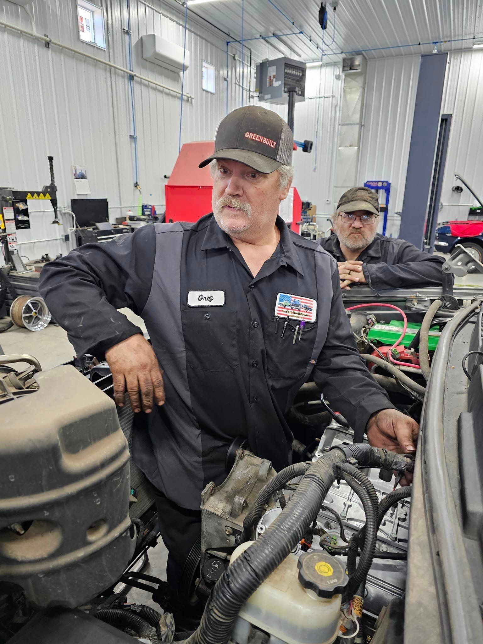 a man is working on a car engine in a garage .