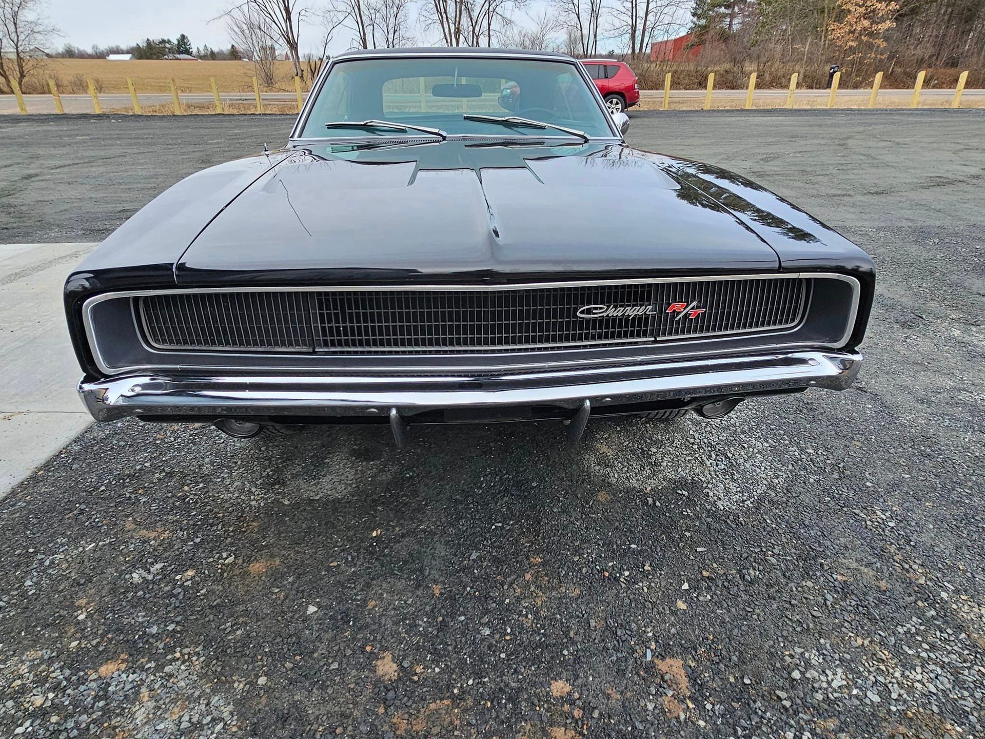 a black dodge charger is parked in a parking lot .