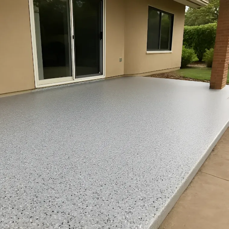 Covered patio with a light gray speckled concrete floor beside sliding glass doors