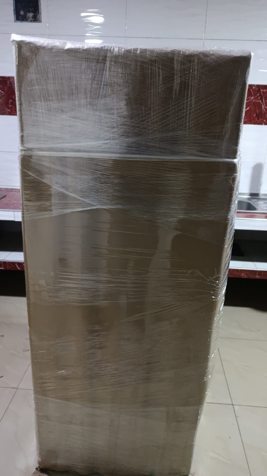 Caja de cartón alta envuelta en plástico transparente