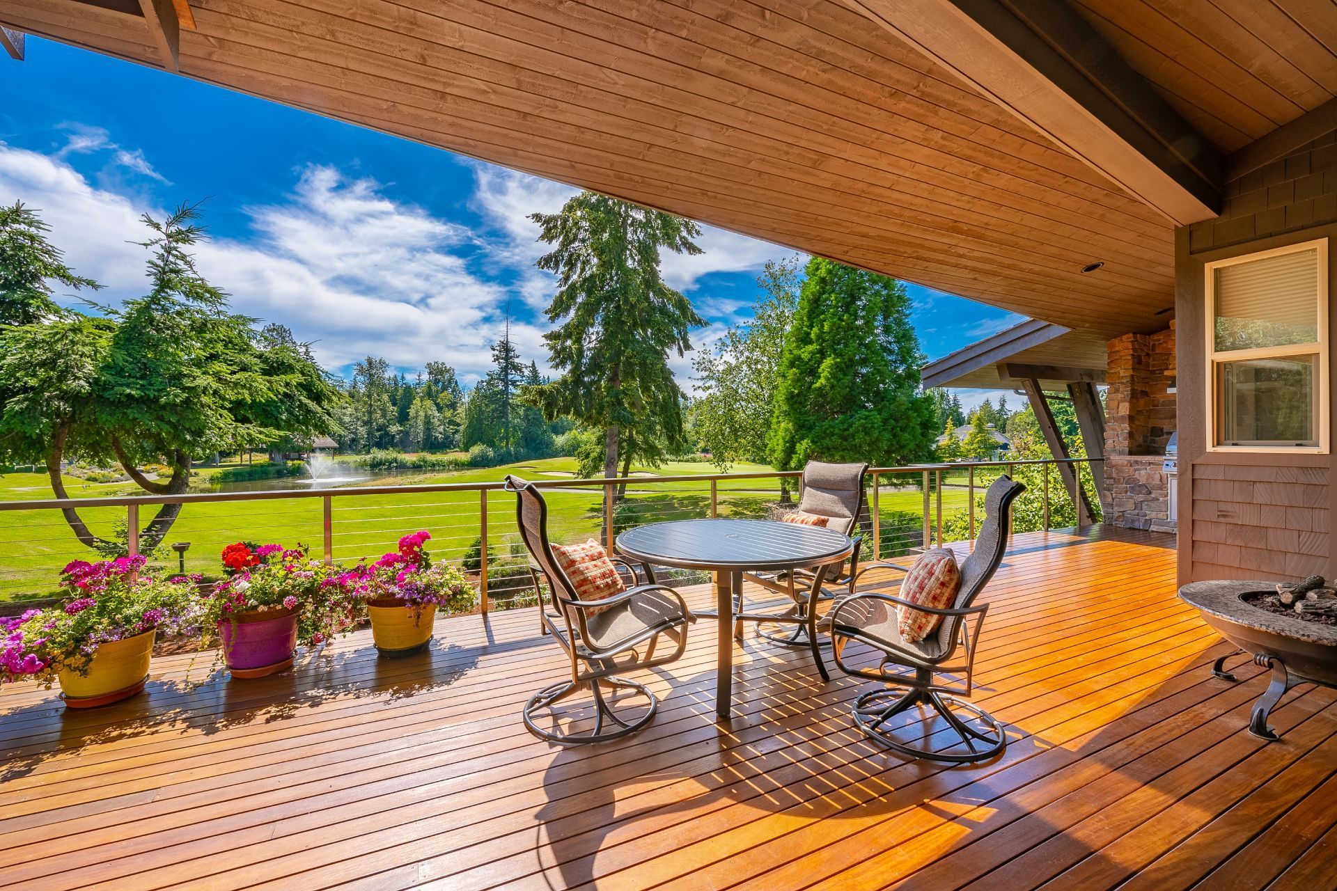There is a large wooden deck with a table and chairs on it.