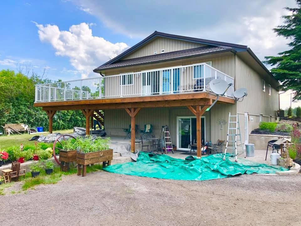 A large house with a large deck and a satellite dish.
