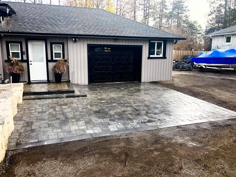 A house with a garage and a boat in the driveway.