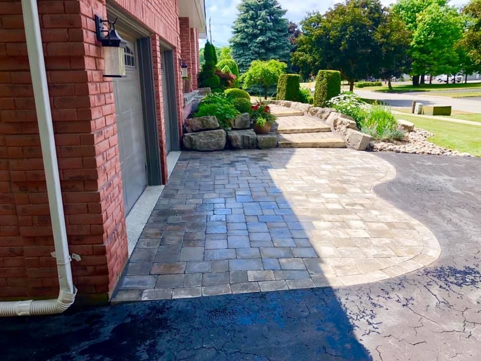 A brick house with a driveway and a brick walkway leading to it.
