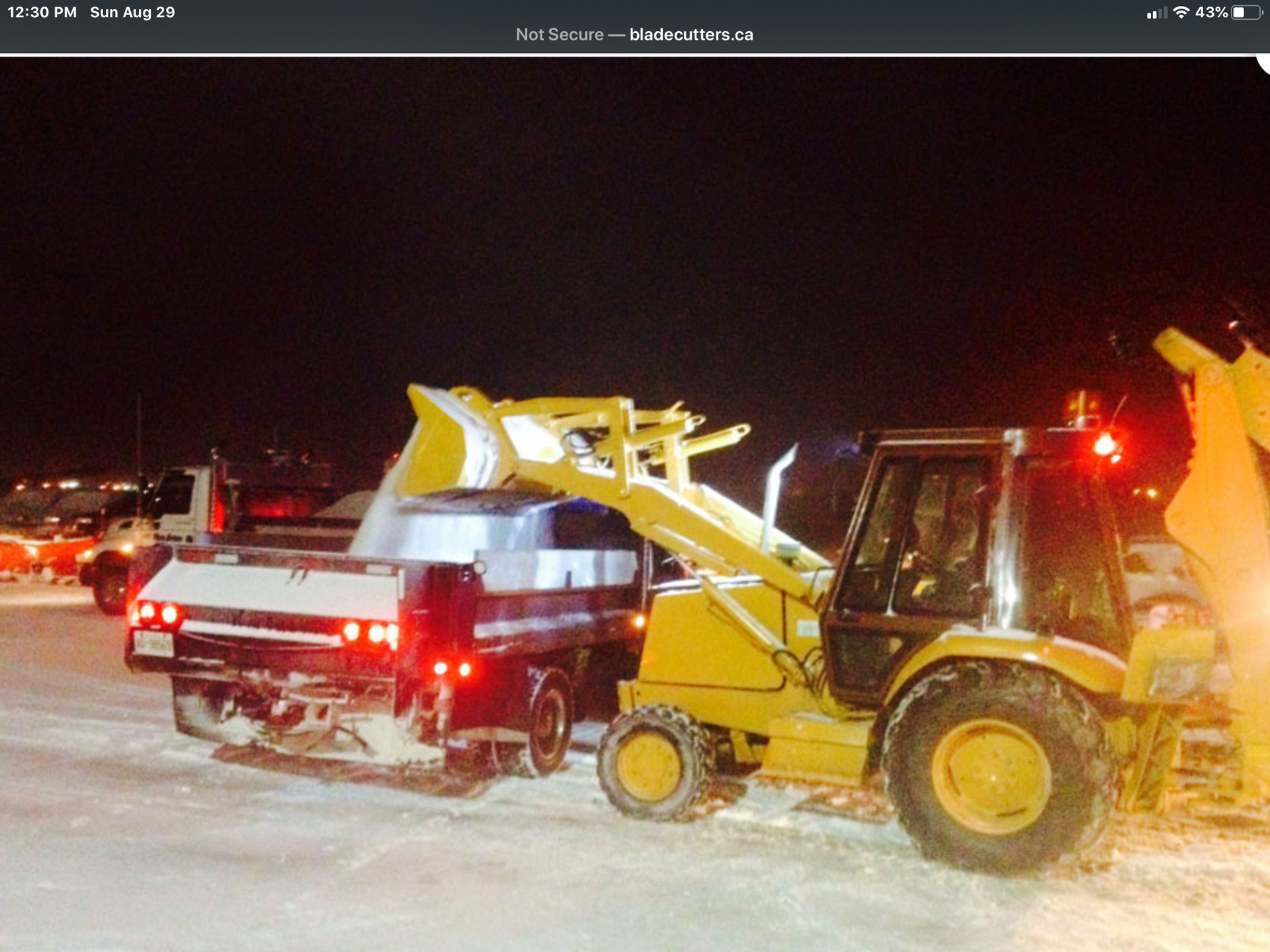 A truck is being towed by a yellow tractor