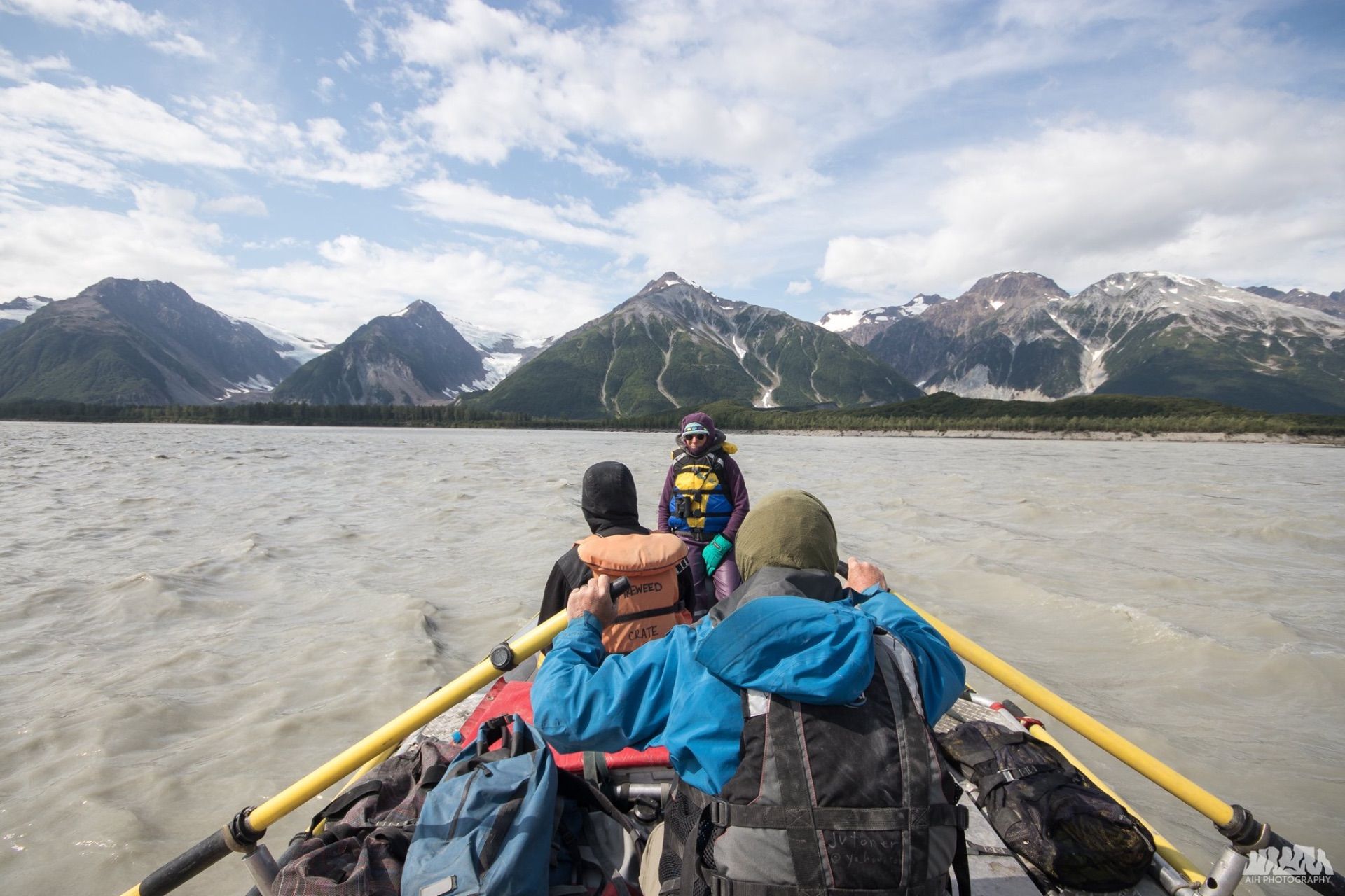 People rowing a raft on a lake, mountains