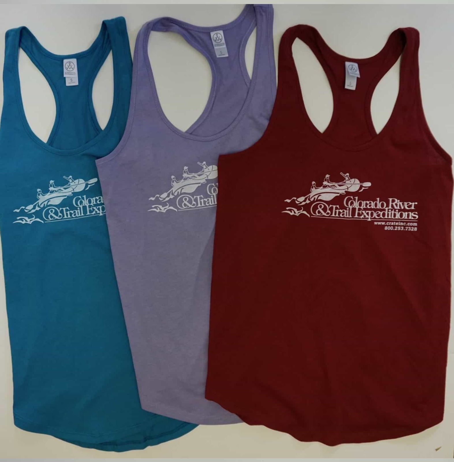 Three tank tops: teal, purple, and maroon, with a black graphic on each.