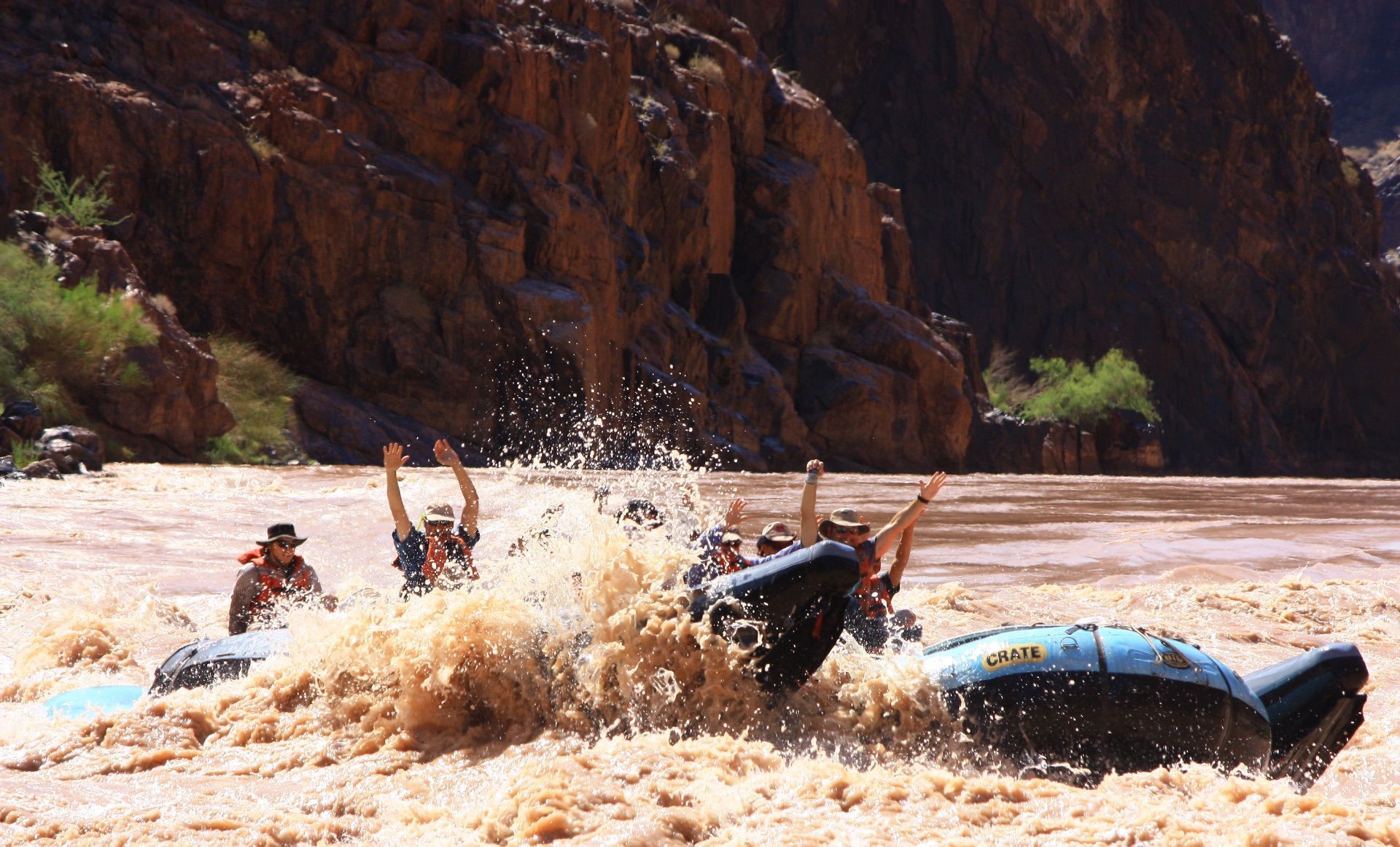 Cataract Canyon River with boats in front of a large rock formation