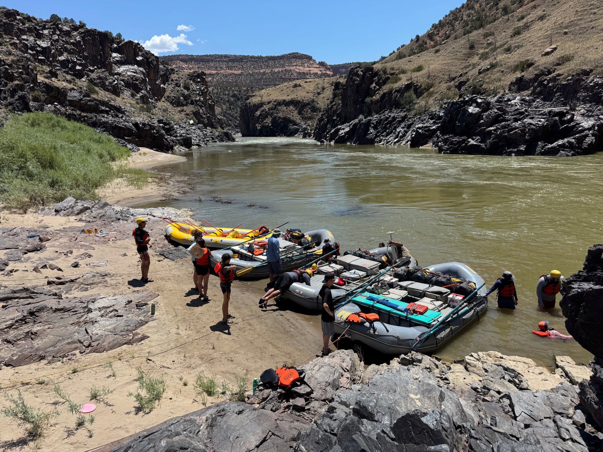 Rafting on a river with rafts beached on a sandy shore