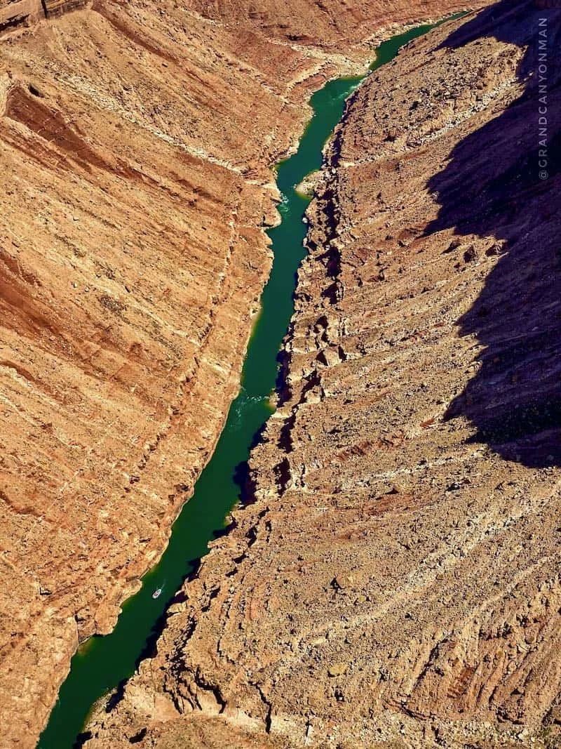 Green river winding through a deep, reddish-brown canyon.