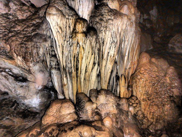 Cave formation: cream and tan stalactites and stalagmites.