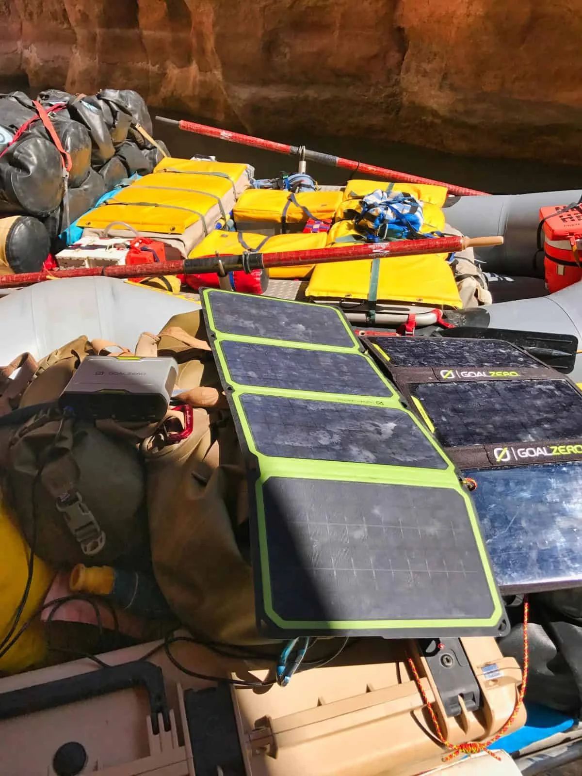 Solar panels on a raft with gear, in a canyon setting.