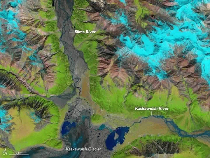 Satellite view: Rivers, mountains, glacier, and vegetation in shades of green, brown, blue, and white.
