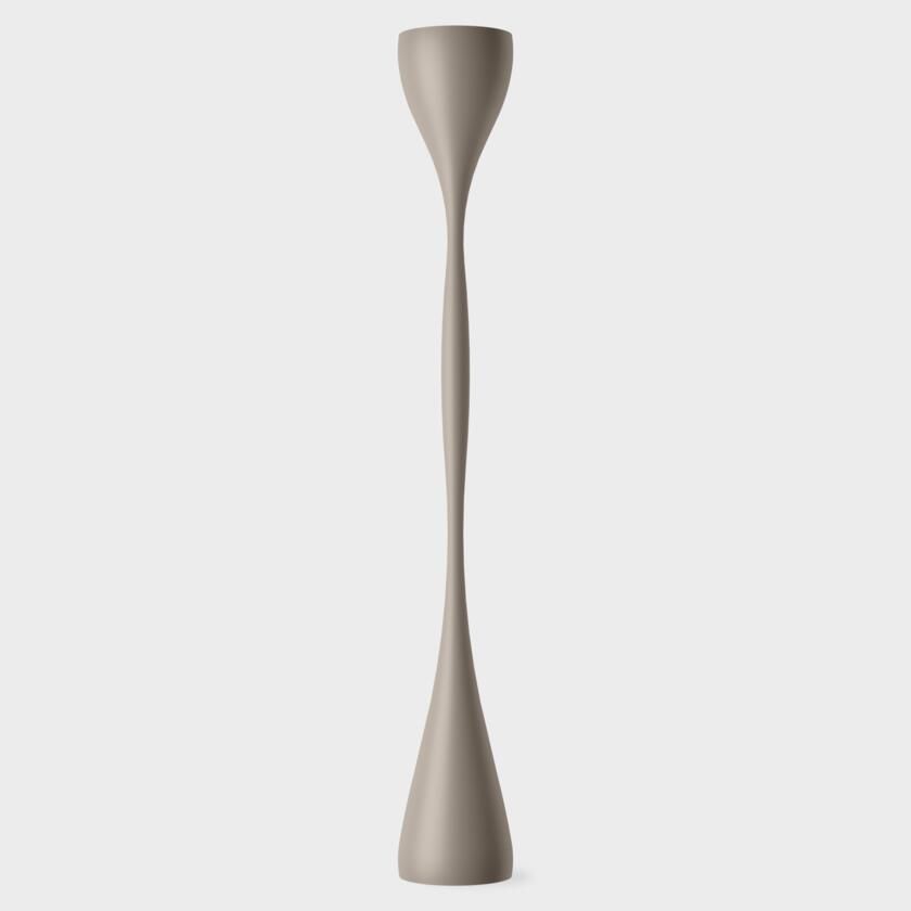 Una lámpara de pie alta, de color marrón claro, con una base de pedestal delgada y curvada y una parte superior acampanada sobre un fondo gris claro liso.