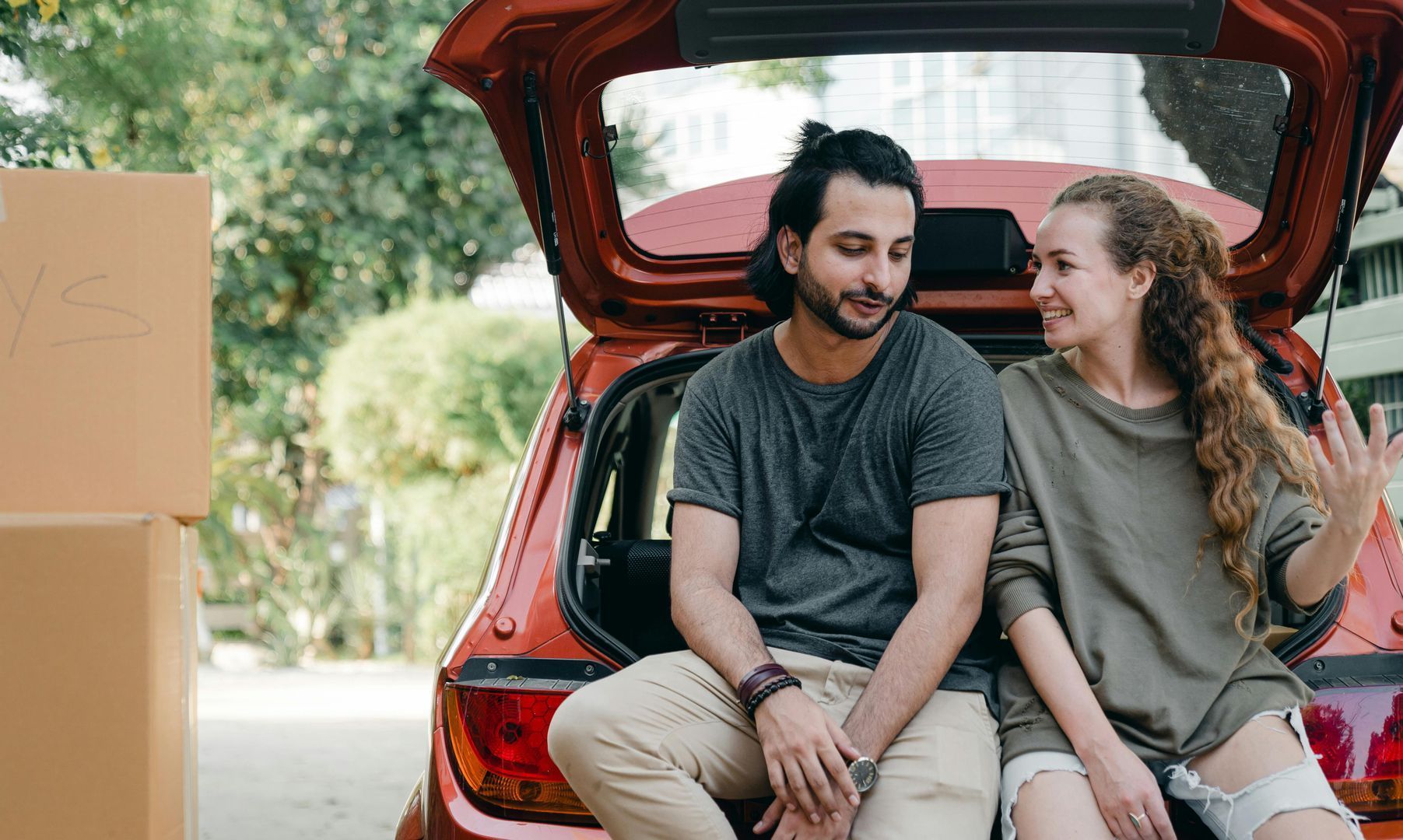 A man and a woman are sitting in the back of a car.